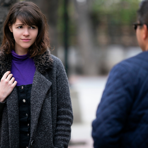 Woman looking cautiously at a man walking by